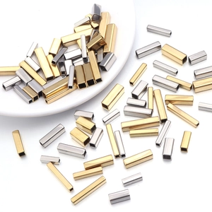 Gros plan de perles tubes rectangulaires en acier inoxydable or et argent pour bijoux DIY