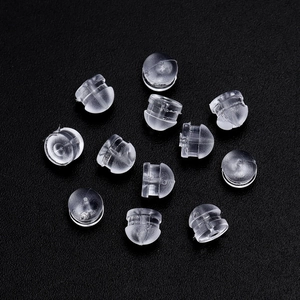 Macro detail of transparent plum flower silicone earring backs on a black background