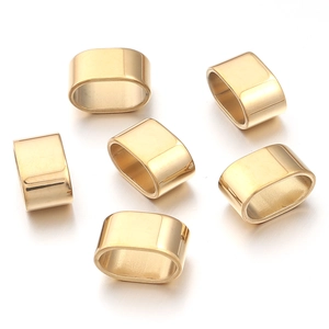 Detalle macro de cuentas ovaladas de acero inoxidable dorado para joyería de bricolaje