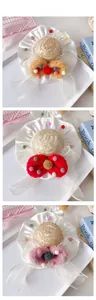 Detailed view of three sweet pet straw hats with colorful bows and plush balls