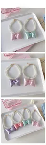 Detail of elegant double-row pearl pet necklaces with sparkling satin bows in pastel colors