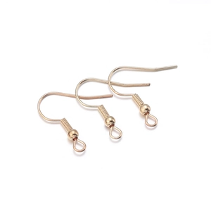 Détail de trois crochets d'oreilles dorés avec ressorts et billes pour bijoux DIY