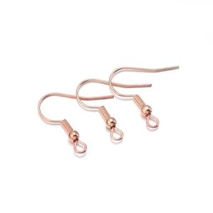Gros plan de trois crochets d'oreilles en or rose avec ressort et boucle pour bijoux DIY