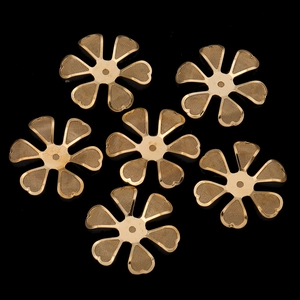 Detailed macro view of golden metal flower charms with mesh texture for DIY jewelry making