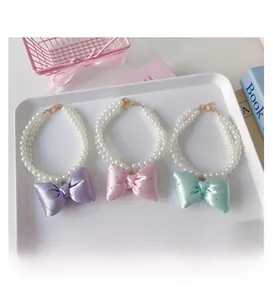 Detail of double-layer faux pearl necklaces with pastel bows for pets in various colors