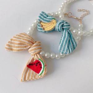 Cute faux pearl pet necklace with striped fabric bows featuring banana and watermelon embroidery