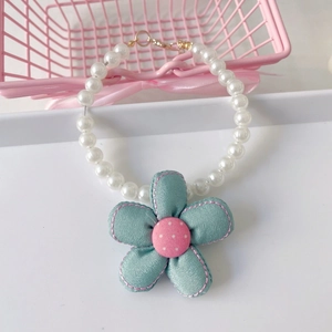 Detailed view of handmade fabric flower charm on double-layer pearl pet necklace