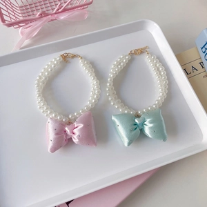 Double-row faux pearl pet collar with oversized glittery bows in pink and mint green