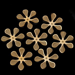Detailed macro view of seven golden filigree mesh flower charms for DIY jewelry making
