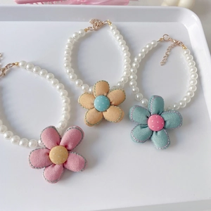 Close-up of pearl pet necklaces with fabric flowers and adjustable gold lobster clasp
