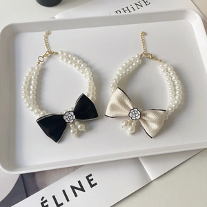 Close-up of double-layer pearl pet collar with camellia bow and adjustable gold clasp