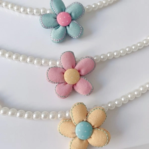 Detail of multi-color fabric flower charms on white pearl necklaces for cats and dogs
