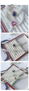 Detailed view of double-layer pet pearl necklaces with floral and gemstone pendants