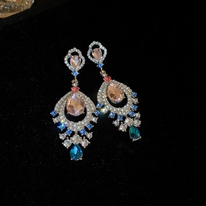 Close-up of vintage court style dangle earrings with multi-colored crystals and zircons.