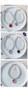 Détail de pendentifs en cristal en forme de cœur et colliers de perles pour animaux