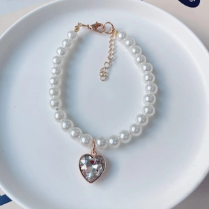 Détail du collier de perles pour animaux avec pendentif cœur en cristal et fermoir doré