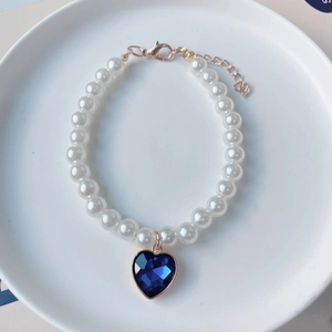 Détail du collier de perles pour animaux avec pendentif cœur bleu et fermoir or rose