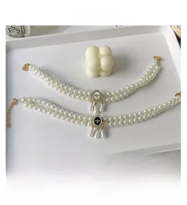 Close-up of double-layer pet pearl necklace with bee pendant and fringe tassels
