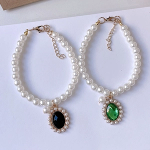 Detalle de collares de perlas para mascotas con colgantes ovalados negros y verdes vintage