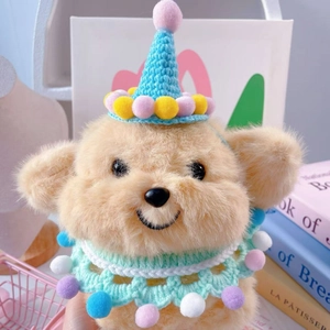 Close-up of cute plush dog doll wearing colorful knitted party hat and lace scarf decor