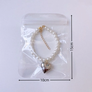 Detail of vintage pearl pet necklace with silver heart pendant in clear packaging