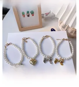 Detail of pet pearl necklaces with gold and silver heart and bow pendants and chains