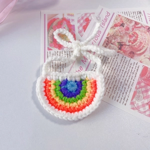 Gros plan du bavoir arc-en-ciel au crochet pour animaux avec liens blancs ajustables