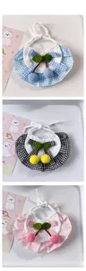 Detail of handmade crocheted pet bibs with cherry accents and plaid patterns