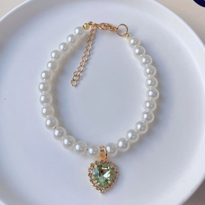 Elegant pearl pet necklace featuring a green heart pendant with crystal border