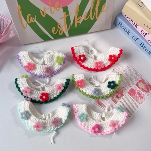 Dettaglio di sei collari per animali fatti a mano con piccoli fiori colorati all'uncinetto