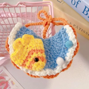 Close-up of handmade blue and white knitted pet bib with a cute 3D small fish detail