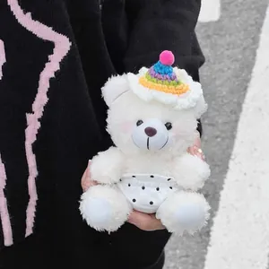 Gros plan d'un ours en peluche blanc avec bonnet au crochet arc-en-ciel et short