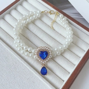 Detail of double-layer pearl necklace with blue heart gem and water drop pendant for pets