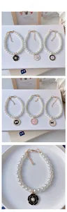 Detail of white faux pearl pet collar with camellia flower and bow enamel pendants