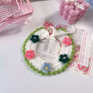 Dettaglio collare bianco lavorato a maglia per animali con fiori all'uncinetto colorati
