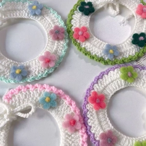 Dettaglio di collari per animali fatti a mano all'uncinetto con fiori colorati e trama a maglia