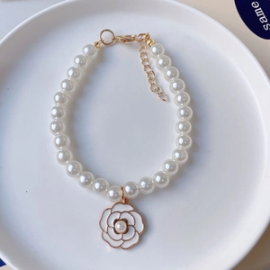 Close-up of pearl pet necklace with camellia pendant and gold adjustable clasp