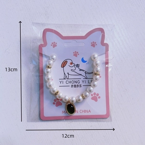 Colorful pearl pet necklace with green gemstone pendant for cats and dogs on white wood