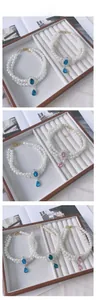Detail of double-layer pearl pet necklace with sparkling colorful gemstone pendants