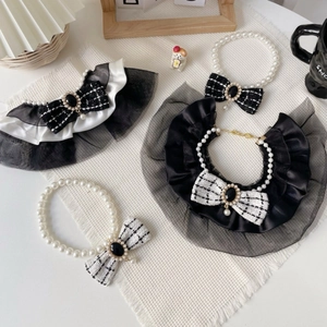 Detail of luxury pet pearl necklaces and lace bibs with tweed bows and pearl buckles