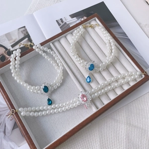 Detail of double-layer pearl pet necklaces with colorful teardrop crystal pendants