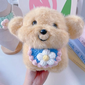 Close-up of plush toy dog wearing a colorful handmade crochet bib with flower detail