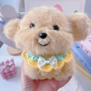Close-up of plush puppy doll wearing a yellow-green crochet bib with white silk bow