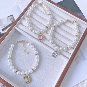 Detailed macro view of pearl pet necklaces with colorful rectangular crystal pendants
