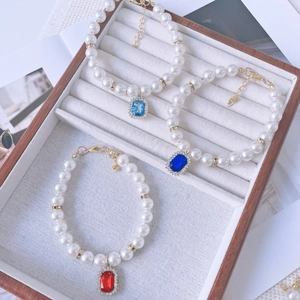 Detailed view of pearl bracelets with colorful crystal pendants and gold-plated clasp