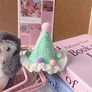 Handmade knitted Christmas tree pet hat with colorful pom-poms and white ruffled trim