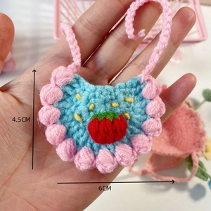 Close-up of handmade crochet mini bib with strawberry detail and 6cm x 4.5cm dimensions