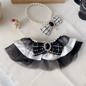 Detail of pet pearl necklace and tweed bow bib with lace ruffles for cats and dogs