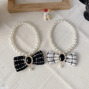 Detail of pet pearl necklace featuring tweed bowknots and vintage water drop pendants