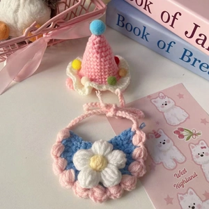 Detailed view of handmade crochet pink party hat and blue bib set with floral decoration
